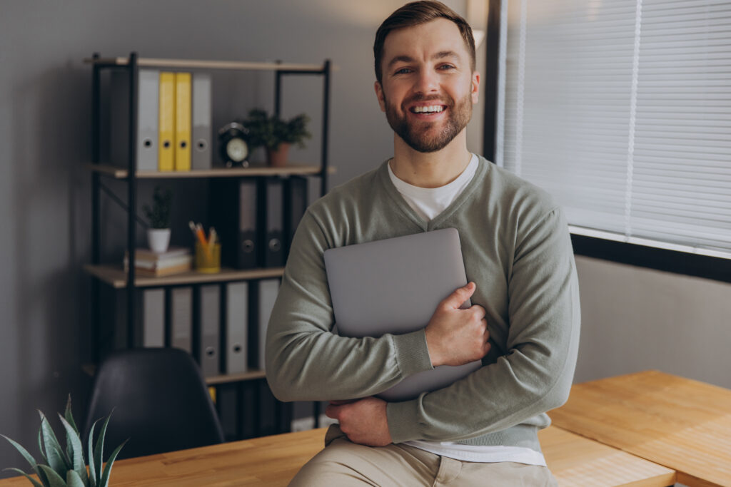 Modern happy bearded office male worker of IT company smiling an